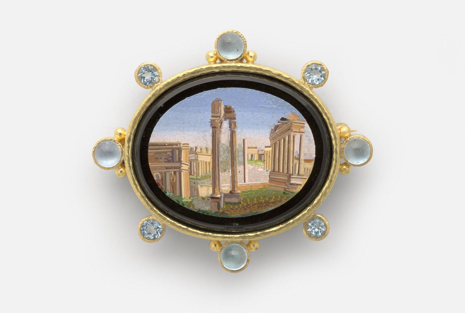 Roman Forum, Rome, 19th century, Micromosaic set in gold as a brooch, with alternating 6-mm cabochon aquamarines with side gold dots and 5-mm faceted aquamarines around bezel; 54 x 62 mm; Collection of Elizabeth Locke; Photo by Travis Fullerton, Virginia Museum of Fine Arts 