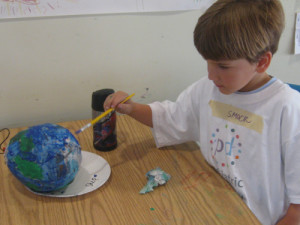 Shep paints a papier-mache globe during Go Green week.