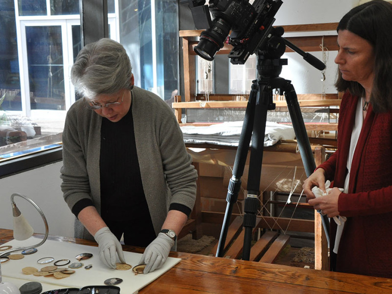 Conservator and curator examine miniature portraits