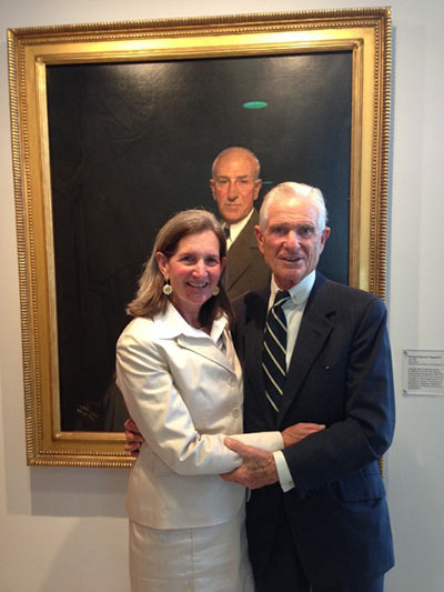 Wendy Lawson-Johnston McNeil with her father Peter Lawson-Johnston standing before a portrait of Solomon R. Guggenheim.