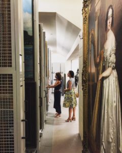 Zinnia Willits showing visitor the painting storage racks
