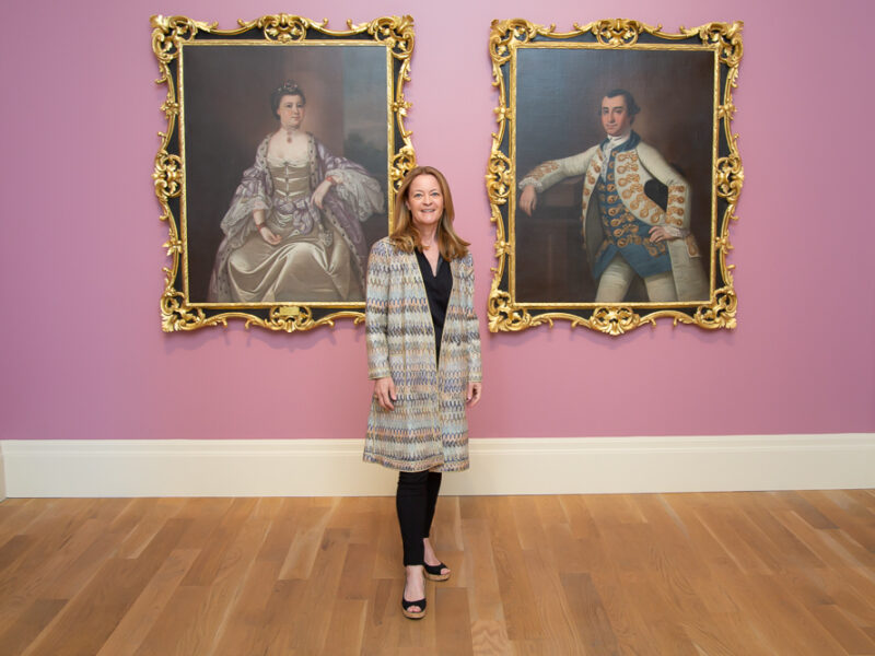 Woman standing in front of 2 paintings