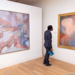Person looking at large abstract paintings