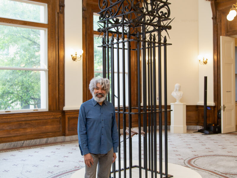 Fred Wilson standing in front of his sculpture