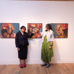 Artist Beverly McIver and curator Kim Boganey in front of paintings