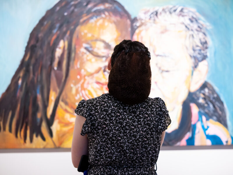 Woman looking at a painting of 2 women